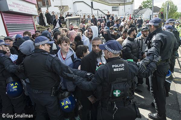 Police holding back anti-fascists.